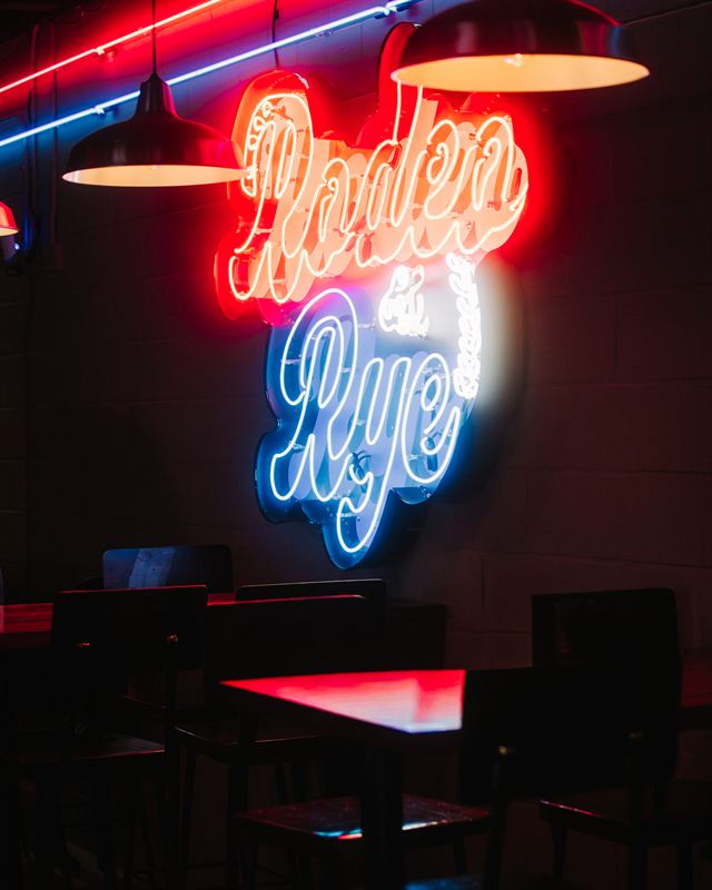 The Rodeo & Rye neon sign glowing over the dining room