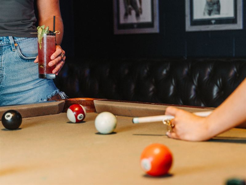 A cocktail in hand at the pool table inside Rodeo & Rye
