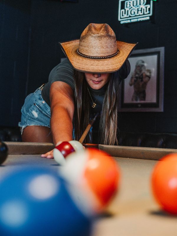 Lining up a shot on the pool table at Rodeo & Rye in Arlington, Texas